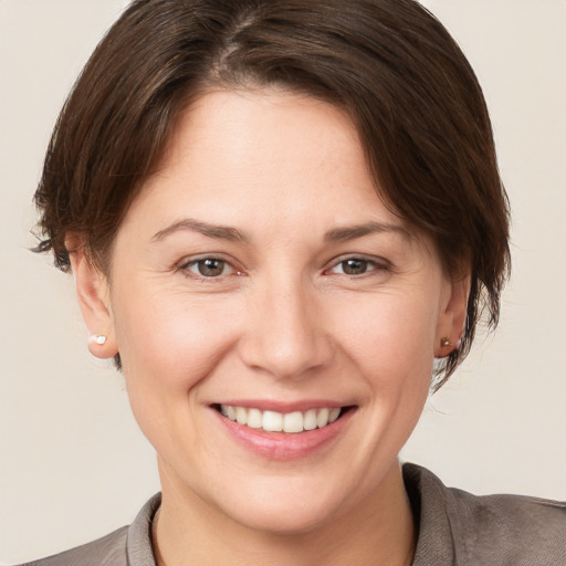 Joyful white young-adult female with short  brown hair and brown eyes