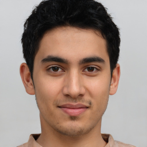 Joyful latino young-adult male with short  brown hair and brown eyes