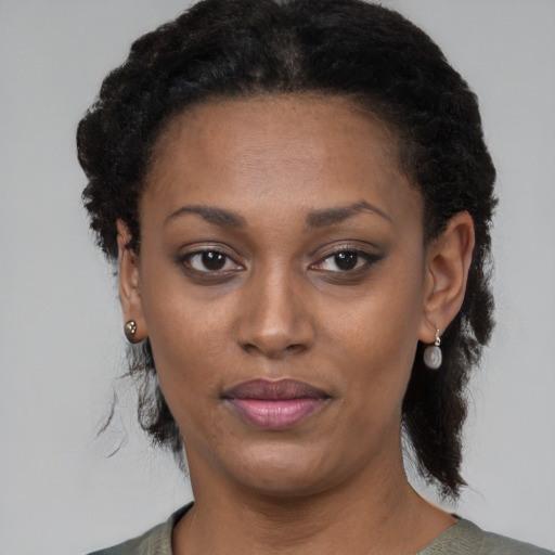 Joyful black adult female with medium  black hair and brown eyes
