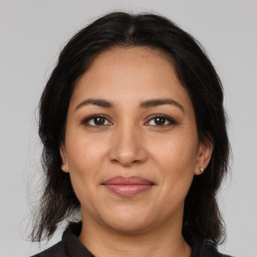 Joyful latino adult female with medium  brown hair and brown eyes
