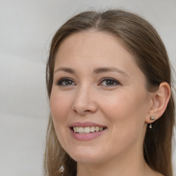 Joyful white young-adult female with long  brown hair and grey eyes