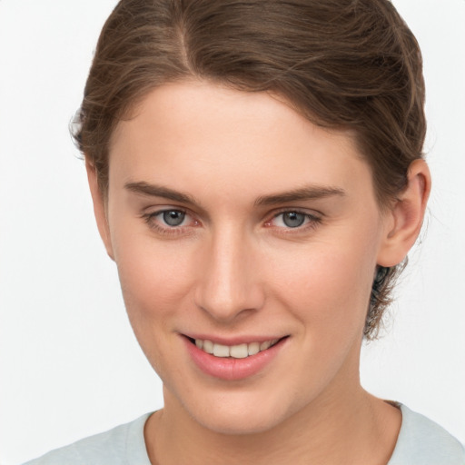 Joyful white young-adult female with short  brown hair and grey eyes