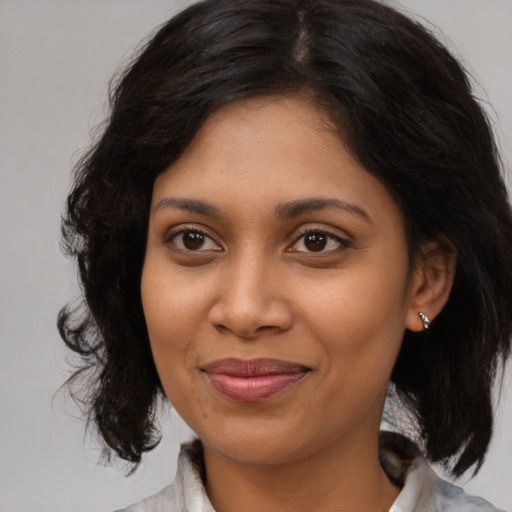 Joyful black young-adult female with medium  brown hair and brown eyes