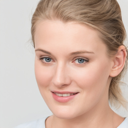 Joyful white young-adult female with medium  brown hair and blue eyes