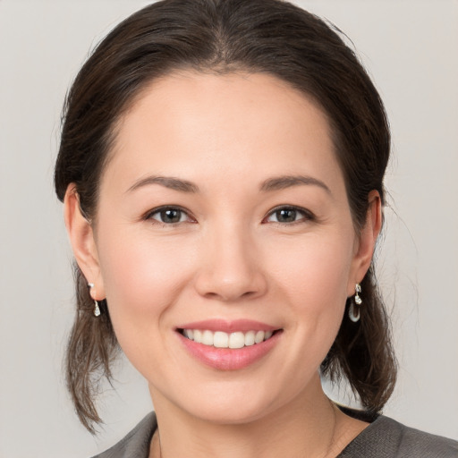 Joyful white young-adult female with medium  brown hair and brown eyes