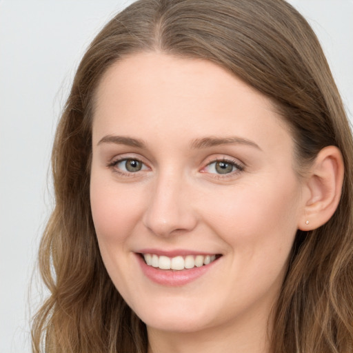 Joyful white young-adult female with long  brown hair and grey eyes