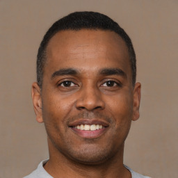 Joyful latino young-adult male with short  brown hair and brown eyes