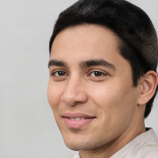 Joyful white young-adult male with short  black hair and brown eyes