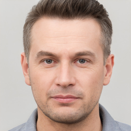 Joyful white adult male with short  brown hair and grey eyes