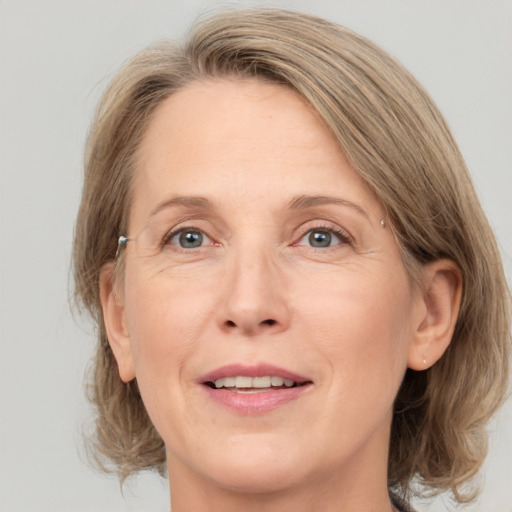 Joyful white adult female with medium  brown hair and grey eyes