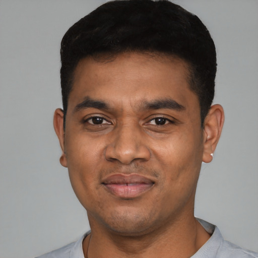 Joyful latino young-adult male with short  black hair and brown eyes