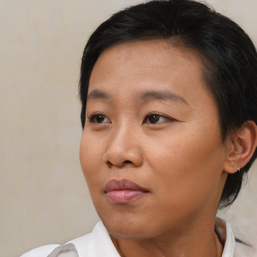 Joyful asian young-adult female with medium  brown hair and brown eyes