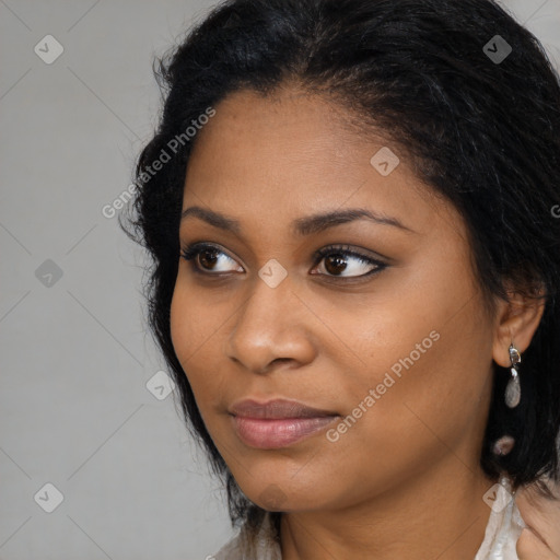 Joyful black young-adult female with long  black hair and brown eyes