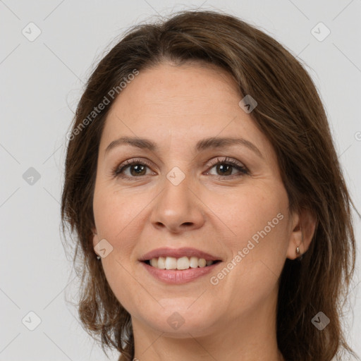 Joyful white adult female with long  brown hair and brown eyes