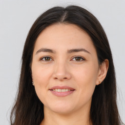 Joyful white young-adult female with long  brown hair and brown eyes