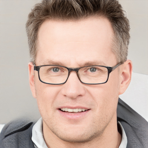 Joyful white adult male with short  brown hair and grey eyes