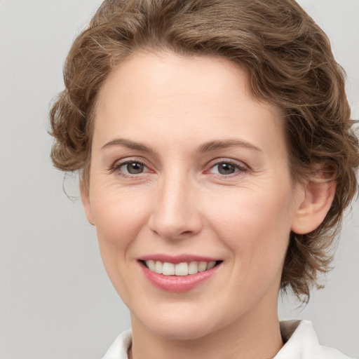 Joyful white young-adult female with medium  brown hair and green eyes