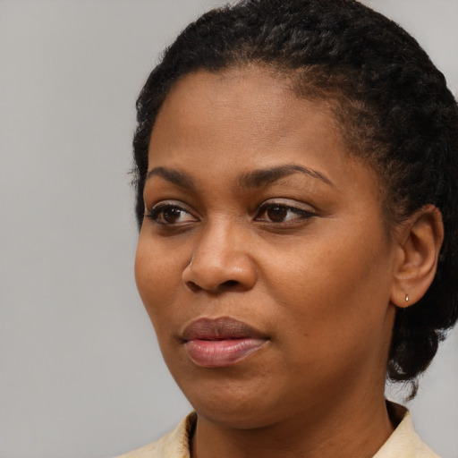 Joyful black young-adult female with short  black hair and brown eyes