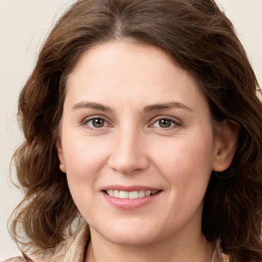 Joyful white young-adult female with long  brown hair and green eyes