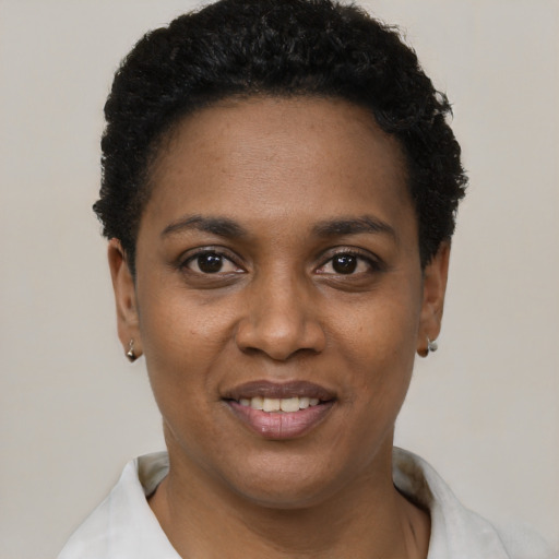 Joyful black young-adult female with short  black hair and brown eyes