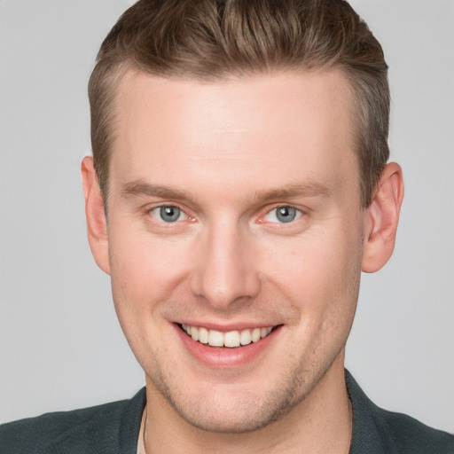 Joyful white young-adult male with short  brown hair and blue eyes