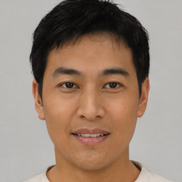 Joyful asian young-adult male with short  black hair and brown eyes