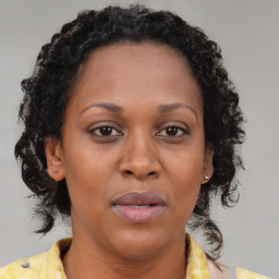 Joyful black adult female with medium  brown hair and brown eyes