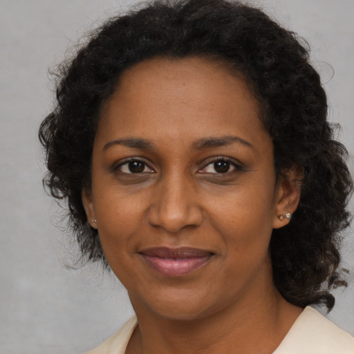 Joyful black adult female with medium  brown hair and brown eyes