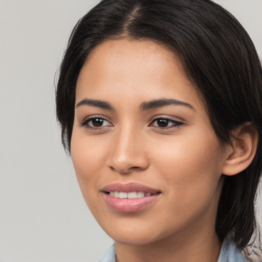 Joyful latino young-adult female with long  brown hair and brown eyes