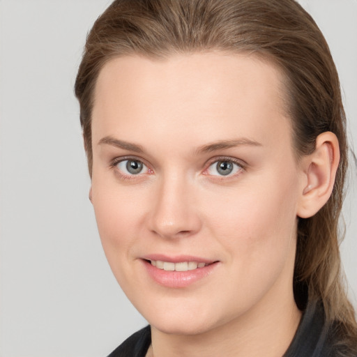 Joyful white young-adult female with long  brown hair and grey eyes