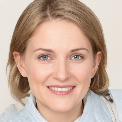 Joyful white adult female with medium  brown hair and blue eyes