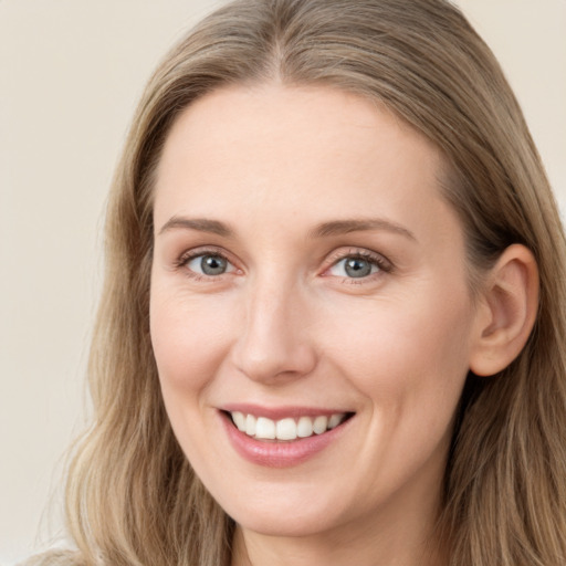 Joyful white young-adult female with long  brown hair and grey eyes