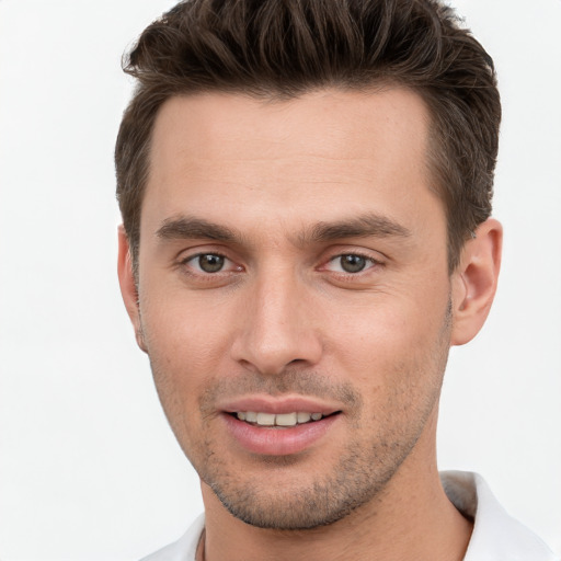 Joyful white young-adult male with short  brown hair and grey eyes