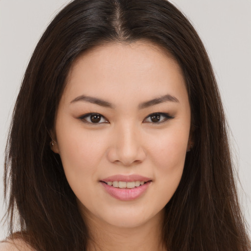 Joyful asian young-adult female with long  brown hair and brown eyes