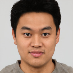 Joyful asian young-adult male with short  black hair and brown eyes