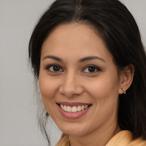 Joyful latino young-adult female with long  brown hair and brown eyes