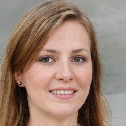 Joyful white young-adult female with medium  brown hair and blue eyes