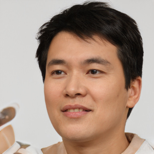 Joyful asian young-adult male with short  brown hair and brown eyes
