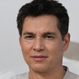 Joyful white adult male with short  black hair and brown eyes