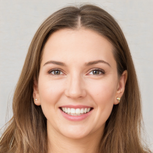 Joyful white young-adult female with long  brown hair and green eyes