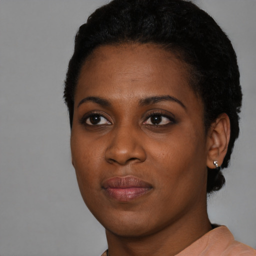 Joyful black young-adult female with short  black hair and brown eyes