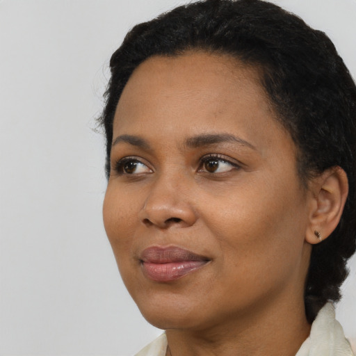 Joyful black adult female with short  black hair and brown eyes