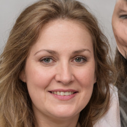 Joyful white adult female with long  brown hair and grey eyes