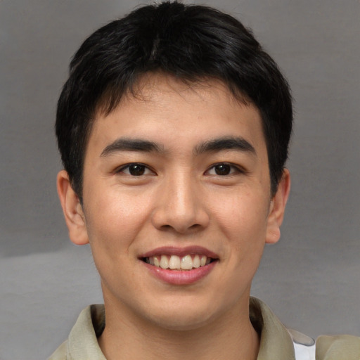 Joyful asian young-adult male with short  brown hair and brown eyes