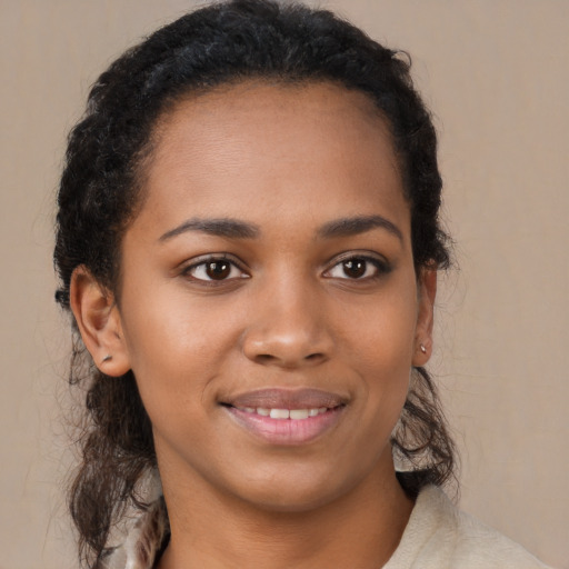 Joyful black young-adult female with long  brown hair and brown eyes