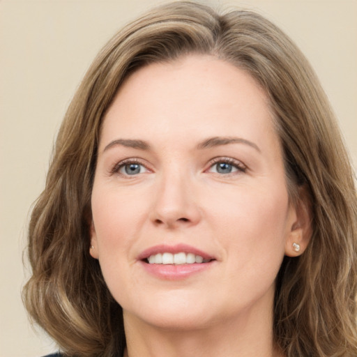 Joyful white adult female with long  brown hair and green eyes