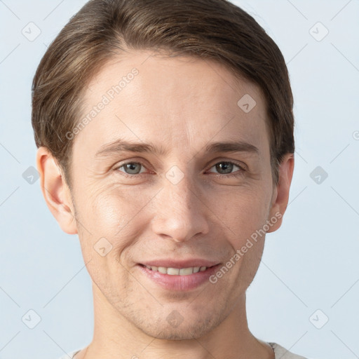 Joyful white young-adult male with short  brown hair and grey eyes