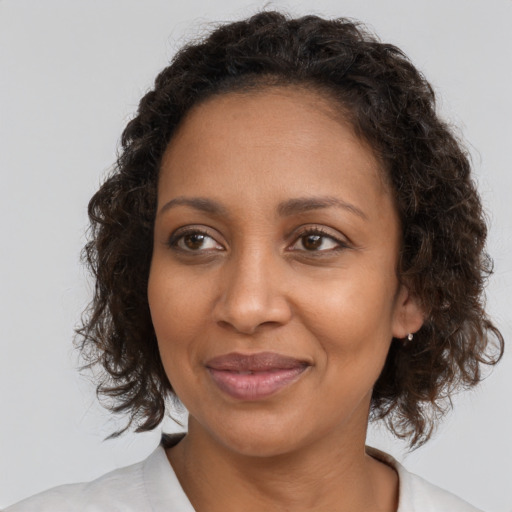 Joyful black adult female with medium  brown hair and brown eyes