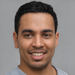 Joyful latino young-adult male with short  black hair and brown eyes