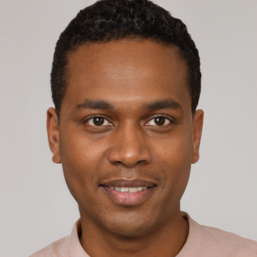 Joyful black young-adult male with short  black hair and brown eyes